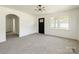 Open living room with fresh paint, new carpet, an arched doorway, and natural light from large windows at 1401 Woodman Hall St, Shelby, NC 28152