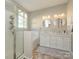 Bathroom featuring a double vanity, white cabinets, and separate glass enclosed shower at 14336 Northridge Dr, Charlotte, NC 28269