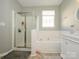 Bright bathroom featuring a glass shower, soaking tub, and vanity with modern fixtures and a window for natural light at 14336 Northridge Dr, Charlotte, NC 28269