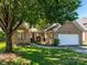 Charming brick home with a two-car garage and a well-manicured lawn, shaded by a large tree at 14336 Northridge Dr, Charlotte, NC 28269