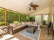 Inviting sunroom with a comfortable seating area, ceiling fan, and views of the lush surrounding greenery at 14336 Northridge Dr, Charlotte, NC 28269