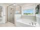 Bathroom featuring glass enclosed shower, large tub, and window for natural light at 145 Yellow Birch Loop, Mooresville, NC 28117
