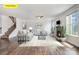 Staged living room features a stone fireplace, hardwood floors, and staircase to the left at 145 Yellow Birch Loop, Mooresville, NC 28117