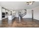 Open concept living area connects to a bright kitchen with hardwood floors and staircase at 145 Yellow Birch Loop, Mooresville, NC 28117