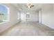 Bright main bedroom featuring tray ceiling, neutral carpet, large windows, and ensuite access at 145 Yellow Birch Loop, Mooresville, NC 28117