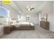Stylishly staged main bedroom with a large bed, wood furnishings, and tray ceiling at 145 Yellow Birch Loop, Mooresville, NC 28117