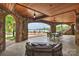 Expansive covered patio with stone columns, ceiling fans, lake views, and outdoor seating creates an inviting space at 16909 Jetton Rd, Cornelius, NC 28031