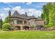 Sprawling lakefront home featuring a covered patio, balconies, lush lawn and manicured grounds at 16909 Jetton Rd, Cornelius, NC 28031