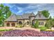 Stunning stone home with a circular driveway, turret, and mature landscaping at 16909 Jetton Rd, Cornelius, NC 28031