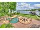 Aerial view of an outdoor pool, hot tub, and dock area on a lake at 16909 Jetton Rd, Cornelius, NC 28031