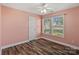 Small bedroom with wood floors, a ceiling fan, two windows, and pink walls at 1961 Leesburg Dr, Clover, SC 29710
