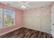 Small bedroom with wood floors, a ceiling fan, one window, wainscotting and pink and floral walls at 1961 Leesburg Dr, Clover, SC 29710