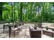 Outdoor patio with dining and sitting area surrounded by a lush and mature backyard landscape at 218 Kingsway Cir, Charlotte, NC 28214