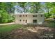 Spacious backyard featuring a lush lawn, a concrete patio, and mature trees, perfect for outdoor entertaining at 218 Kingsway Cir, Charlotte, NC 28214
