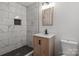 Modern bathroom with a walk-in shower, marble tile, a wood vanity, and updated fixtures at 218 Kingsway Cir, Charlotte, NC 28214