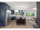 Modern kitchen features an island with seating, modern lighting, stainless steel appliances, and an adjacent dining area at 218 Kingsway Cir, Charlotte, NC 28214