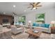 Staged living room featuring natural light, light-colored wood flooring, and modern ceiling fans at 218 Kingsway Cir, Charlotte, NC 28214