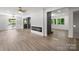 Spacious living area with sleek fireplace, light-colored wood flooring, and a modern ceiling fan at 218 Kingsway Cir, Charlotte, NC 28214