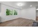 Bright living room with ample natural light, wood-look floors, and white walls creates a spacious and airy atmosphere at 218 Kingsway Cir, Charlotte, NC 28214