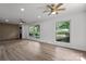 Open living room with plenty of natural light, light-colored wood flooring, and modern ceiling fans at 218 Kingsway Cir, Charlotte, NC 28214