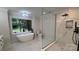 Elegant bathroom featuring a standalone tub, a glass-enclosed shower, and marble flooring at 26056 Neptunes Lndg, Fort Mill, SC 29708
