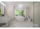 Renovated bathroom featuring soaking tub, vanity, and marble tile at 26056 Neptunes Lndg, Fort Mill, SC 29708