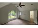 Bright, carpeted bedroom featuring a unique arched window with neighborhood views and a ceiling fan at 26056 Neptunes Lndg, Fort Mill, SC 29708
