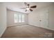 This carpeted bedroom boasts a ceiling fan and large windows at 26056 Neptunes Lndg, Fort Mill, SC 29708