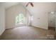 Spacious bedroom with vaulted ceiling, ceiling fan, neutral carpet, and large arched window at 26056 Neptunes Lndg, Fort Mill, SC 29708