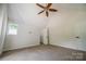 Neutral carpeted bedroom featuring a ceiling fan, walk-in closet, and window at 26056 Neptunes Lndg, Fort Mill, SC 29708