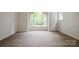 Bedroom featuring neutral carpet, arched windows and view to exterior nature at 26056 Neptunes Lndg, Fort Mill, SC 29708