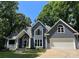 Charming two-story home featuring a front-facing garage, gray siding, and a well-manicured lawn surrounded by mature trees at 26056 Neptunes Lndg, Fort Mill, SC 29708