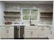 Updated kitchen with white cabinets, floating wood shelves, farmhouse sink and tile backsplash at 26056 Neptunes Lndg, Fort Mill, SC 29708