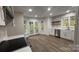 Updated kitchen with tile backsplash, stainless appliances, wood grain vinyl floors, and modern lighting at 26056 Neptunes Lndg, Fort Mill, SC 29708