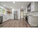 Open kitchen with stainless steel appliances, white cabinets, wood shelving and a farmhouse sink at 26056 Neptunes Lndg, Fort Mill, SC 29708