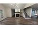 Open-concept living room with fireplace, wood grain vinyl floors, staircase and natural light at 26056 Neptunes Lndg, Fort Mill, SC 29708