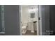 Stylish powder room with a pedestal sink, round mirror, and modern lighting fixtures at 26056 Neptunes Lndg, Fort Mill, SC 29708