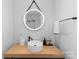 Modern bathroom featuring a round vessel sink, wood countertop, and stylish round mirror with mounted towel bar at 2913 Lake Ave, Charlotte, NC 28208
