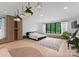 Airy bedroom with large window, hardwood floors, hanging plants, and custom built in cabinets at 2913 Lake Ave, Charlotte, NC 28208