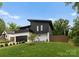 Contemporary home with a unique roofline, black siding, white brick accents, and a lush green lawn at 2913 Lake Ave, Charlotte, NC 28208