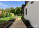 Beautifully landscaped backyard with manicured lawn, flower beds, and a stone walkway leading to a grill at 2913 Lake Ave, Charlotte, NC 28208