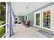 Relaxing screened porch with tile flooring, rocking chairs, and tranquil views of the surrounding trees at 322 Killian Rd, Stanley, NC 28164
