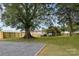 Large backyard with mature trees, a gravel parking area, and a wooden fence at 330 17Th Nw St, Hickory, NC 28601