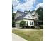 Charming two-story home featuring a manicured lawn, stone accents, a side-entry garage, and a welcoming covered porch at 3320 Harvey Ln, Monroe, NC 28110