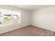 Bright bedroom featuring a large window with neighborhood views and neutral carpeting at 3331 Burberry Dr, Gastonia, NC 28052