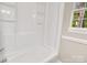 Clean, well-maintained bathtub with tiled surround and convenient shelving at 3637 Glenville Rd, Charlotte, NC 28215
