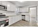 Bright kitchen with stainless steel appliances, granite countertops, and white cabinets at 3637 Glenville Rd, Charlotte, NC 28215