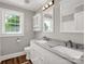 Modern bathroom featuring double sinks, granite countertops, wood-look flooring, and bright natural light at 411 W Sycamore St, Lincolnton, NC 28092