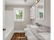 Modern bathroom featuring double sinks, granite countertops, wood-look flooring, and bright natural light at 411 W Sycamore St, Lincolnton, NC 28092