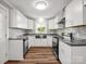 Well-lit kitchen with stainless steel appliances, gray countertops, a modern backsplash, and white cabinets at 411 W Sycamore St, Lincolnton, NC 28092